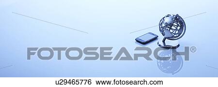 Stock Photograph - A globe and a mobile phone. Fotosearch