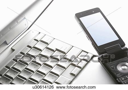 Stock Photograph - A mobile phone and a notebook PC. Fotosearch