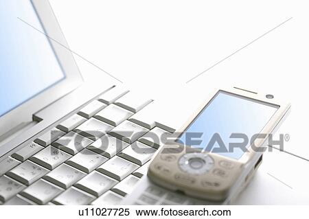 Stock Photography - A mobile phone and a notebook PC. Fotosearch