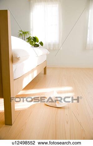 Stock Image - A pair of slippers next to bed. Fotosearch