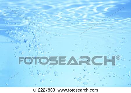 Stock Image - Air bubbles in water, close up, blue background. Fotosearch