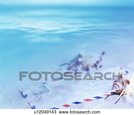 Stock Image - Airmail envelope on the beach. Fotosearch