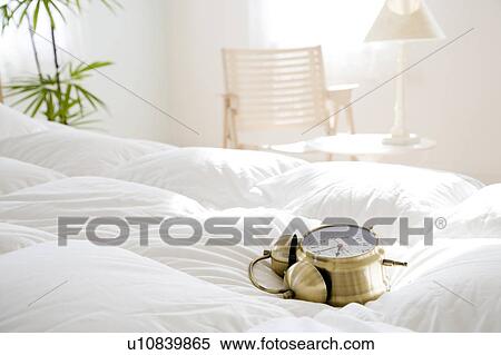 Stock Photography - Alarm clock on bed. Fotosearch