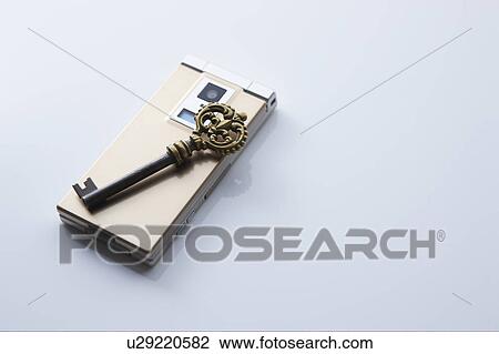 Stock Image - Antique key on mobile phone. Fotosearch