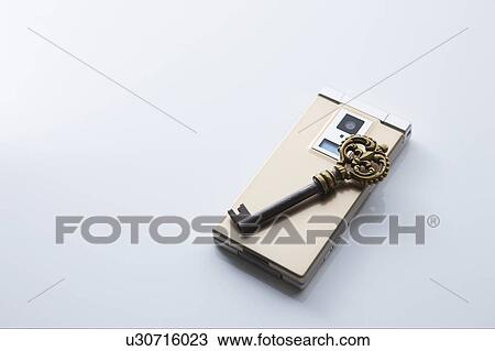 Stock Image - Antique key on mobile phone. Fotosearch