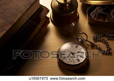 Stock Image - Antique pocket watch and books. Fotosearch