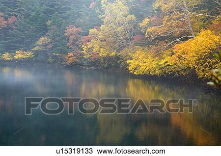 Stock Image - Autumn foliage reflected in lake, Fukushima Prefecture, Japan. Fotosearch