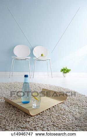 Bottle of water and glass on tray in house View Large Photo Image Stock Photo - Bottle of water and glass on tray in house. Fotosearch