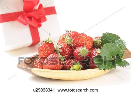 Stock Image - Bowl of strawberries and a gift. Fotosearch