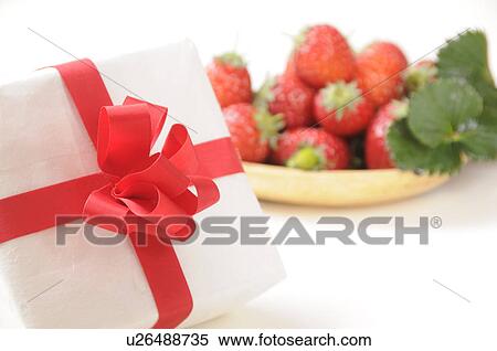 Stock Photography - Bowl of strawberries and a gift. Fotosearch