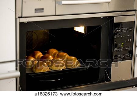 Bread rolls baking in an oven View Large Photo Image Stock Image - Bread rolls baking in an oven. Fotosearch