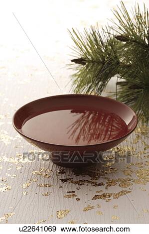 Stock Photo - Brown saki cup with pine branches. Fotosearch