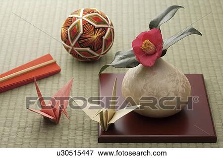 Stock Photo - Camellia in a vase with paper cranes and a temari ball. Fotosearch