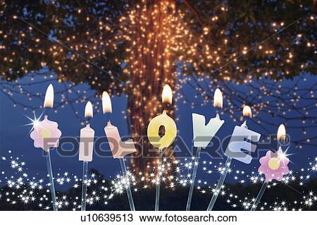 Stock Image - Candles in front of Christmas tree. Fotosearch