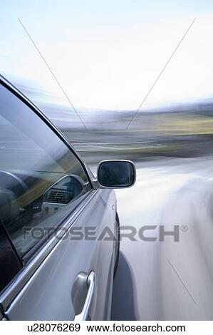 Stock Photo - Car driving around a bend in the road. Fotosearch