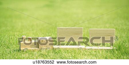 Stock Image - Carved wooden train on a lawn. Fotosearch