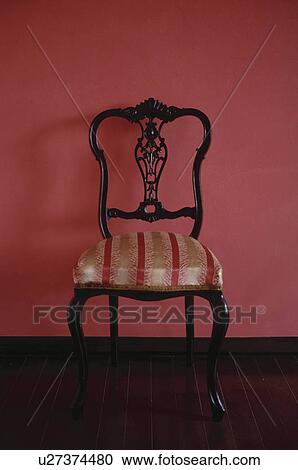 Stock Image - Chair against pink wall. Fotosearch