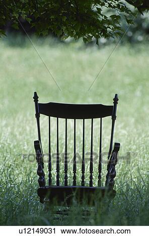Stock Image - Chair in meadow with long grass. Fotosearch