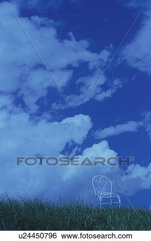 Stock Photograph - Chair on hill against cloudy sky. Mt Yatsugatake, Yamanashi Prefecture, Japan. Fotosearch