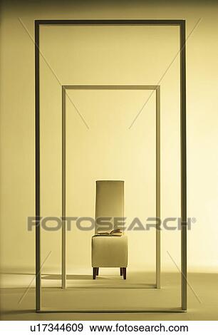 Stock Photo - Chair with a book on it surrounded by frames. Fotosearch