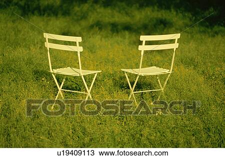 Chairs in meadow with long grass View Large Photo Image Stock Image - Chairs in meadow with long grass. Fotosearch