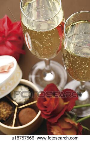 Stock Photograph - Champagne glasses, roses and a gift box of truffles. Fotosearch