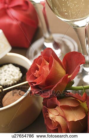 Champagne glasses, roses and a gift box of truffles View Large Photo Image Stock Photograph - Champagne glasses, roses and a gift box of truffles. Fotosearch