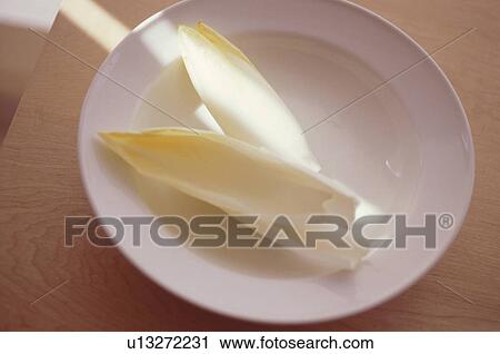 Chicory leaves on white plate View Large Photo Image Stock Image - Chicory leaves on white plate. Fotosearch