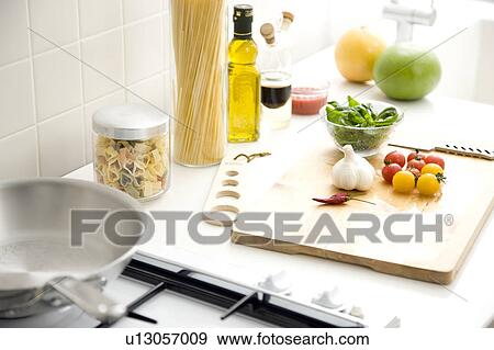 Stock Photo - Chopping board with cherry tomatoes and garlic. Fotosearch
