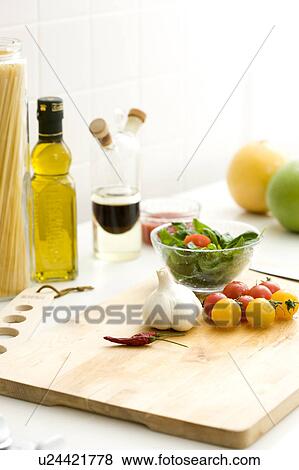 Stock Photo - Chopping board with cherry tomatoes and garlic. Fotosearch