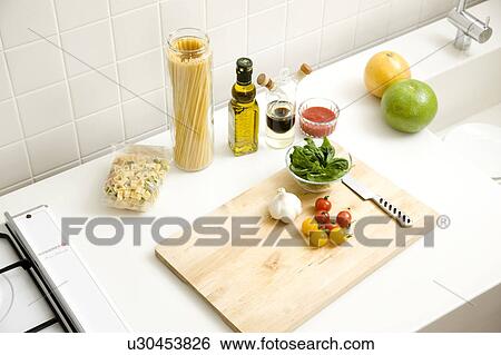 Stock Photograph - Chopping board with cherry tomatoes and garlic. Fotosearch