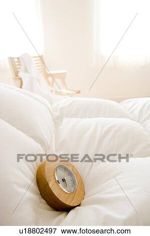 Stock Photo - Clock on bed. Fotosearch
