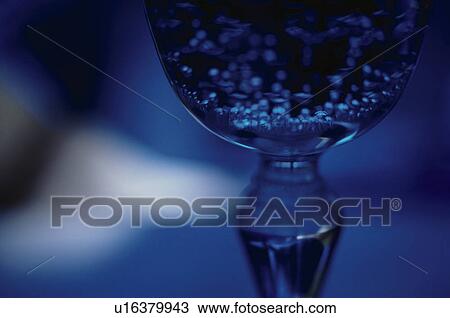 Stock Image - Close-up of glass in blue light. Fotosearch