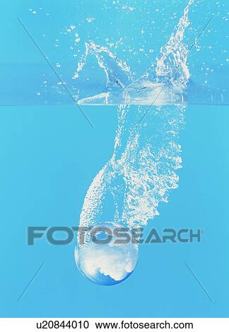 Stock Image - Crystal ball falling into water. Fotosearch