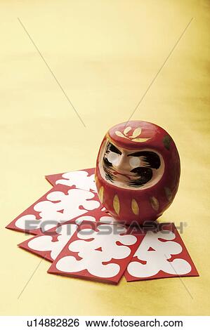 Stock Photograph - Daruma doll and Japanese New Years playing cards. Fotosearch