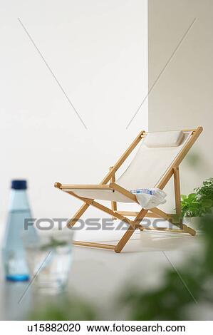Stock Image - Deck chair with bottled water and a towel. Fotosearch
