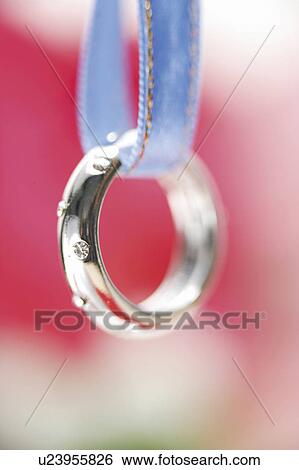 Diamond ring hanging from a blue ribbon View Large Photo Image Stock Photograph - Diamond ring hanging from a blue ribbon. Fotosearch