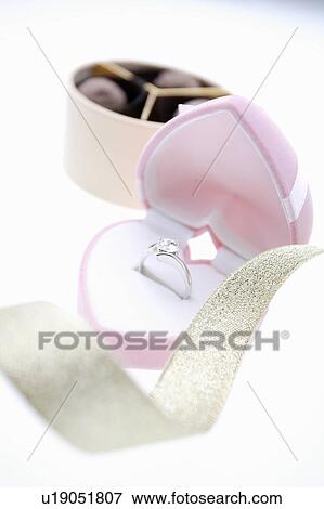 Diamond ring in a heart shaped box and a box of chocolates View Large Photo Image Stock Photo - Diamond ring in a heart shaped box and a box of chocolates. Fotosearch