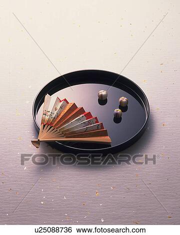 Stock Photograph - Fan and candy on black tray. Fotosearch