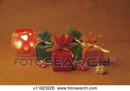 Gift boxes and a candle View Large Photo Image Stock Photograph - Gift boxes and a candle. Fotosearch