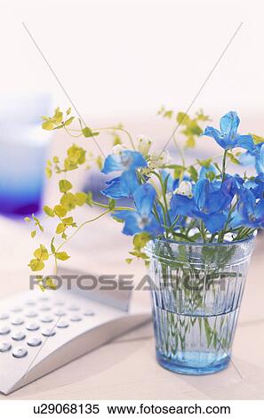 Stock Photography - Glass of flowers on desk with a calculator. Fotosearch
