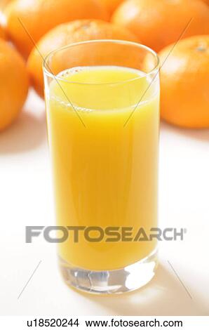 Picture - Glass of orange juice amongst oranges. Fotosearch
