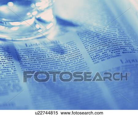 Stock Photography - Glass on an Italian newspaper. Fotosearch