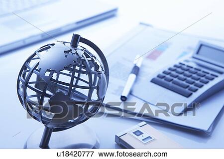 Stock Photo - Globe on a desk with business accessories. Fotosearch