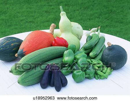 Stock Image - Gourds and peppers on a table. Fotosearch