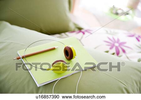 Green headphones and notebook in a bedroom View Large Photo Image Stock Image - Green headphones and notebook in a bedroom. Fotosearch