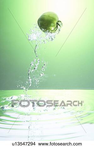Picture - Green tomatoes jumping out of water. Fotosearch