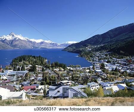 Stock Photo - Houses and mountains surrounding Lake Wakatipu, Queenstown, South Island, New Zealand. Fotosearch