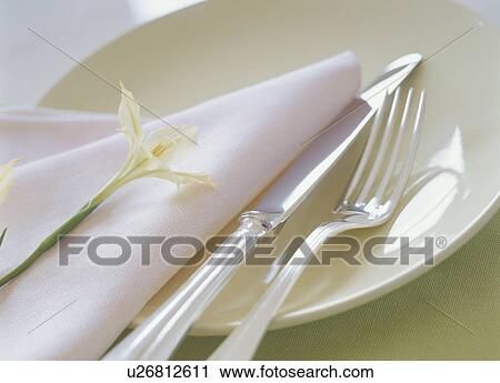 Stock Image - Knife, fork and napkin on plate. Fotosearch