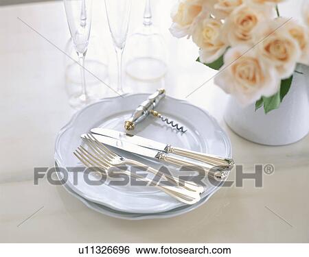 Knives and forks on plates next to flowers View Large Photo Image Stock Photograph - Knives and forks on plates next to flowers. Fotosearch